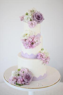 Buttercream wedding cake finished with romantic flowers.