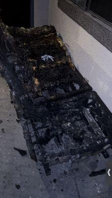 Black leather couch that was burnt to a crisp after squatters set the unit on fire