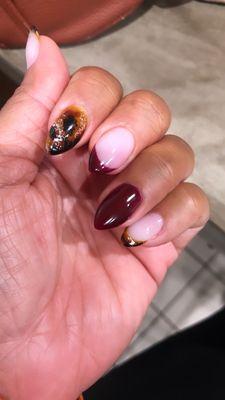 Tortoise shell and deep red french mani almond shaped nails.