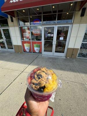 Strawberry mango blueberry smoothie bowl with peanut butter on top for protein