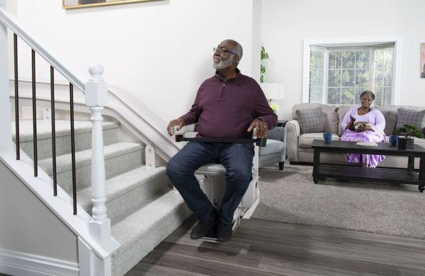 man riding curved stairlift from Lifeway Mobility Charlotte