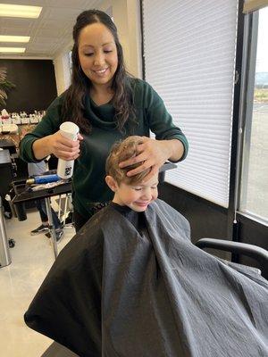 Daisy helping my autistic son with his hair