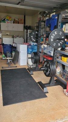 Squat rack, barbell, plates, and mats