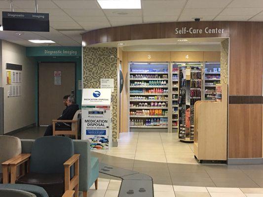 The actual exam room is between the pharmacy and the "Self-Care Center", towards the back left of the room.