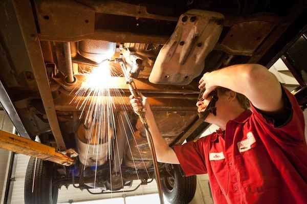 John working underneath a car at Seversin's Auto Repair.