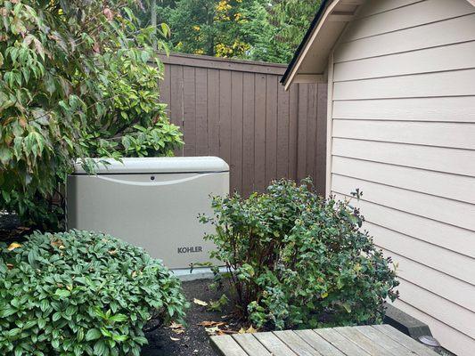 Kohler 20KW standby generator installed remoted of electrical service to blend in with landscape and keep front of house looking clean.