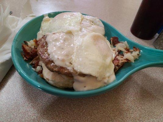 Skillet with hash browns, biscuit, sausage patties, gravy and two eggs -- plentiful & delicious!