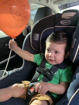 Playing with his balloon after his haircut!