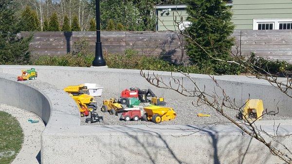 I like how the toy trucks are multiplying in the sandbox area (4/20/21)