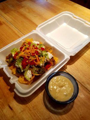 Beef Nachos with lettuce, tomatoes, jalapenos, cheddar cheese & side of Queso