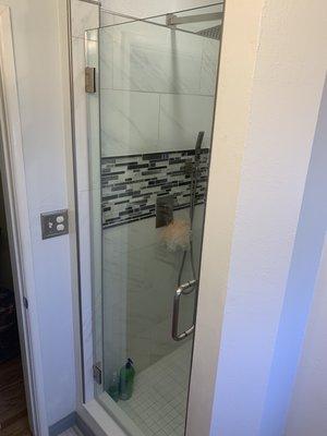 Shower door installed with brush nickel hardware.