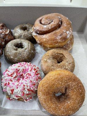 Left row: blueberry glazed and cake w/sprinkles Right row: cinnamon rolls, crumb cake, and cinnamon sugar