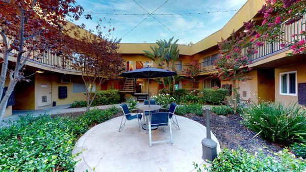 a patio with a table and chairs in a courtyard