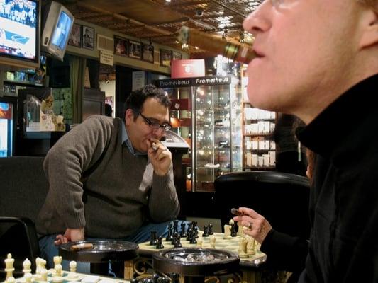 My hubby and friend smoking and playing chess at Cigars by Chivas in Pasadena