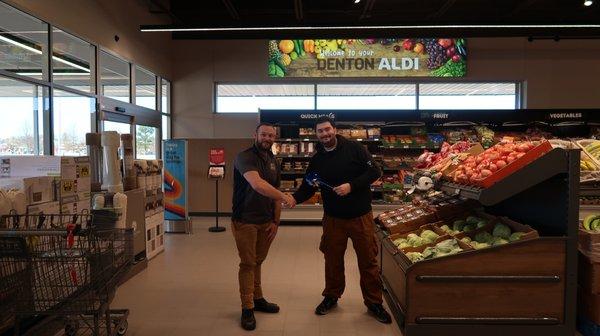 Victor Reynolds receiving a donation from Denton Aldi