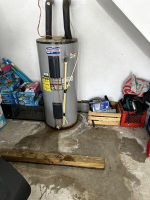 Leaking water heater in a garage before replacement