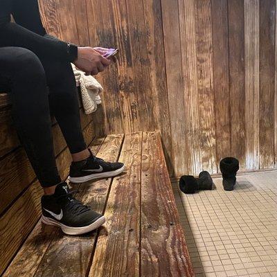 Sauna being used as a drying rack, while someone is wearing their tennis shoes in the sauna