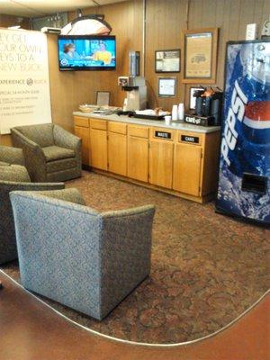 Small waiting area with coffee/tea, soft drink machine, and TV adjacent to both the showroom and the service area.