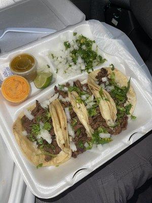 Order of tacos: Carne asada, salsa de chile de árbol (pink), salsa de chile jalapeño (green), onions, cilantro, limes