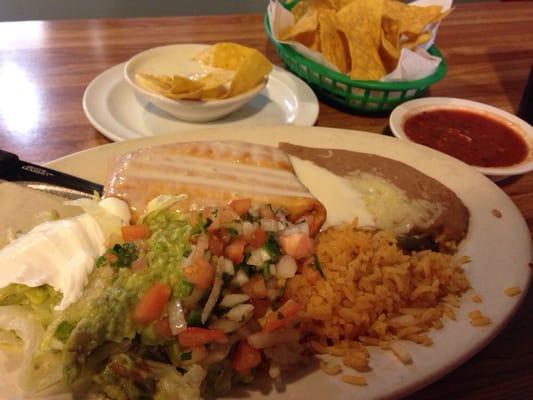 Beef chimichanga with rice, beans, cheese, lettuce, pico de gallo, and guacamole. Chips, salsa and cheese dip.