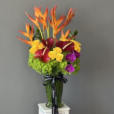 Experience the vibrant beauty of the tropics with our Tropical Rainbow Oasis Tall Arrangement.