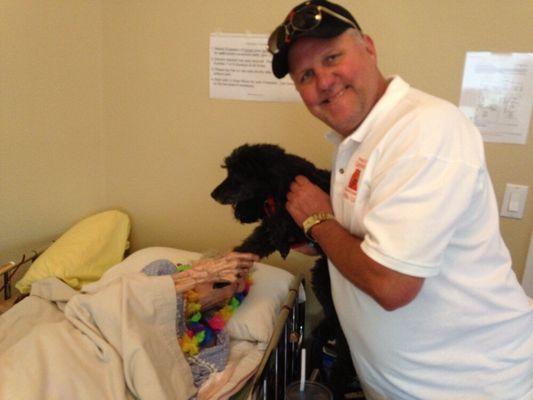 Sydney (our furry friend - middle) visits to cheer residents up! (Pictured here with administrator Albert Wilson).