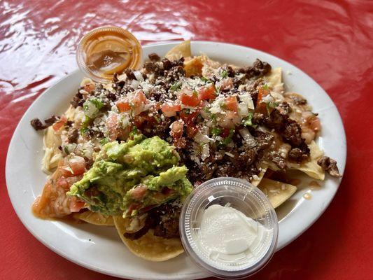 Nachos rancheros de asada. Guacamole was so fresh! Can't beat home style tortilla chips yum!