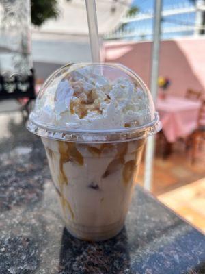 Iced coffee with whipped cream and caramel drizzle