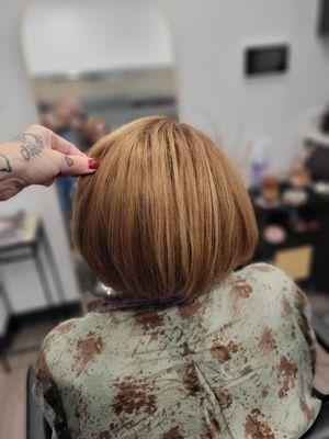 Rootage color with sun kissed highlights and a designer bob haircut.