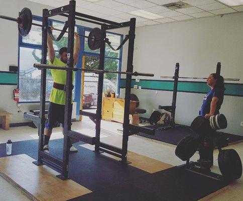 Damon presses 165 lbs overhead while coach Kelly looks on.