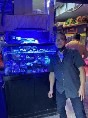 The owner Sam in front of one of his coral tanks