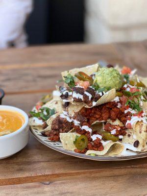 Nachos with mixture of Al Pastor protein and Hamburguesa Mejicana patty with queso on the side. Delish!