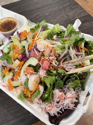 Medium Pokebowl with salmon, tuna and shrimp over field green with sprinkling of brown rice, all fresh toppings