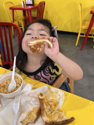 Our little tot enjoying her cheesy meal