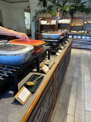 Hot food station including a form of egg Benedict, hash, sausage, dim sum offering and daily carb of rice or noodles