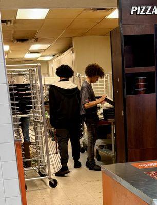 NO HATS, Hair Restraints, just hair all over the place hanging over the Pizzas they are preparing.