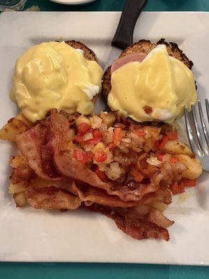 Eggs, Benedict with bacon and home fries with peppers and onions.