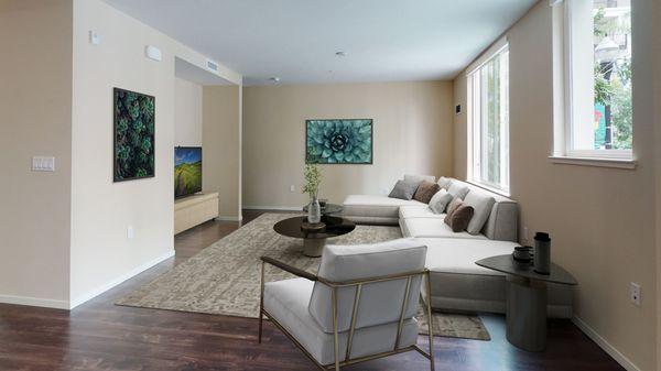 Staged living room featuring hardwood-style vinyl flooring and large windows.