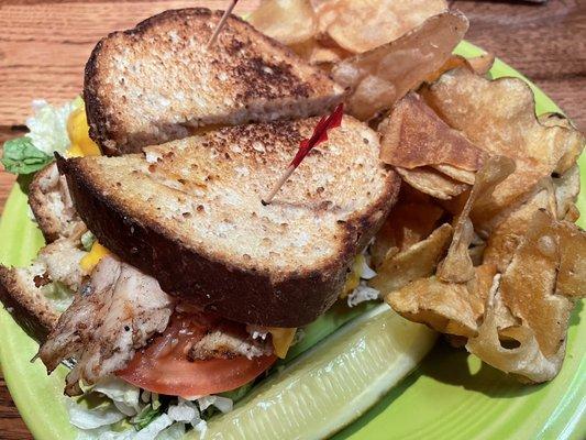 Hot turkey and cheddar sandwich with a side of homemade chips