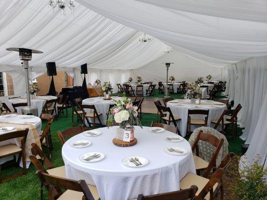 Tables, chairs, tent, draping, lighting, turf, and dance floor