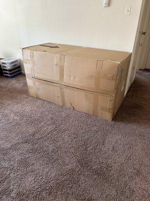 A huge couch sized box in a living room