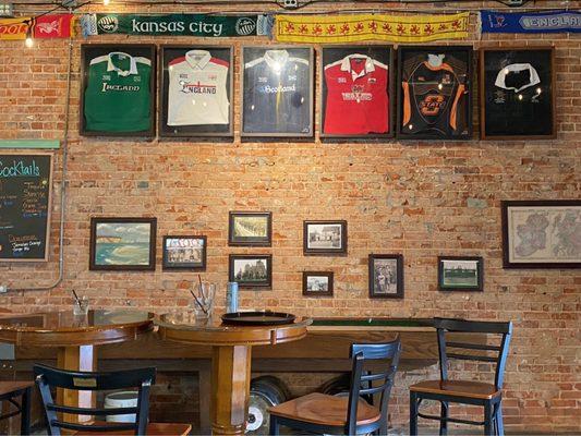 Soccer jerseys and scarves hung on the wall over the shuffleboard table.