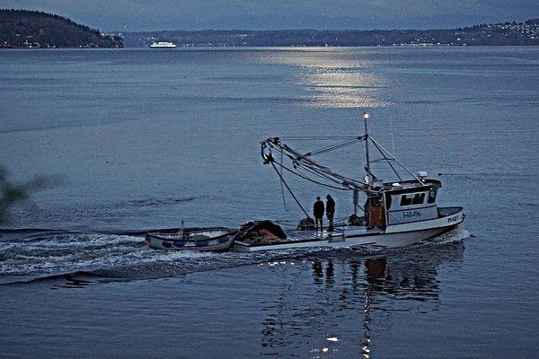 A fishing boat headed out at twilight