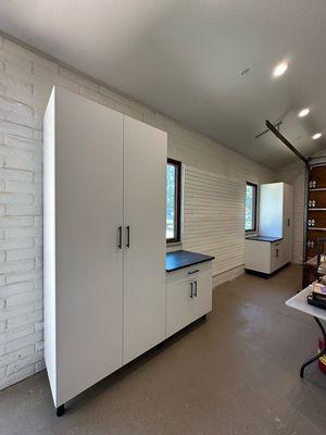 White garage cabinets with black bar handles.