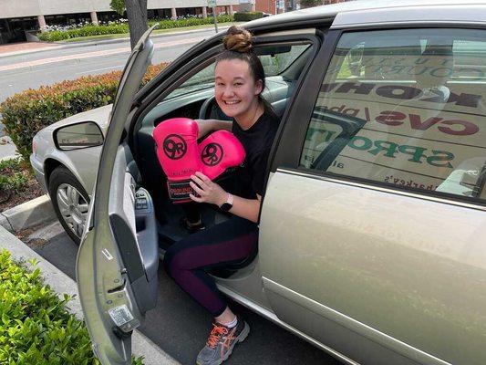 9Round member driving up with a big smile, ready for an amazing workout greeted by our awesome trainer!