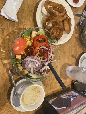 Spinach salad with hot bacon dressing served on the side.