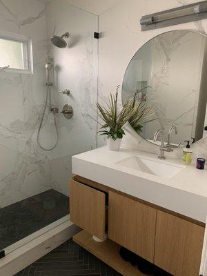 Porcelain and stone walk-in shower with Silestone quartz vanity countertop.