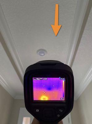 Air conditioning duct had a hole and was leaking conditioned air in the attic. Thermal imaging shows cool spot on ceiling.