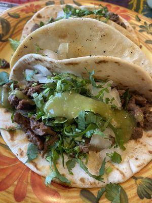 Steak taco, flour tortilla, cilantro and onion and a little green sauce. VERY GOOD. Thank you.