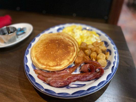 Brunch dish with pancakes, bacon, and eggs